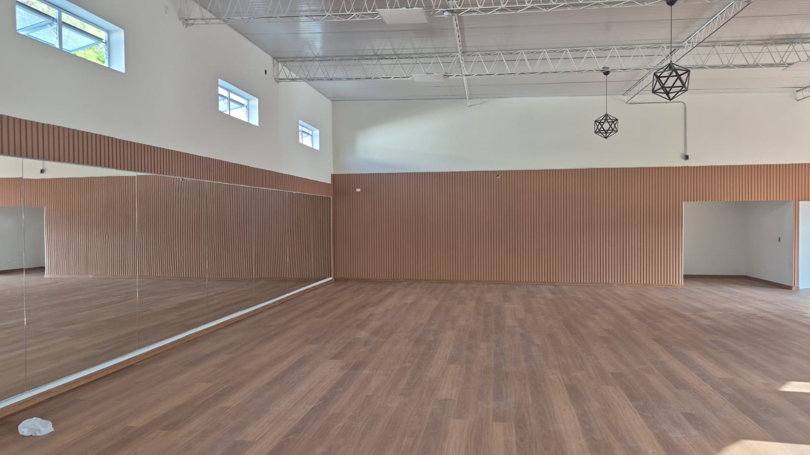 Estudio con panelado de madera y luminarias industriales